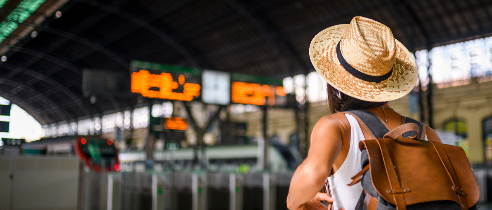 Person in straw hat at train station