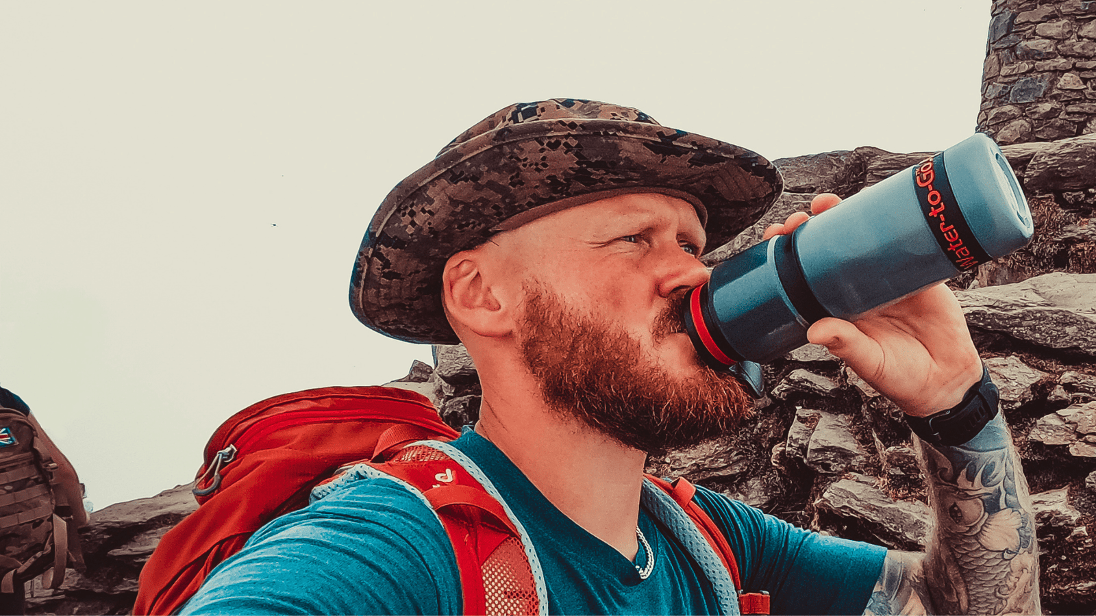 Male hiker drinking from Water to Go water filter bottle