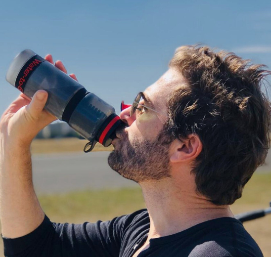 man drinking from water filtration bottle