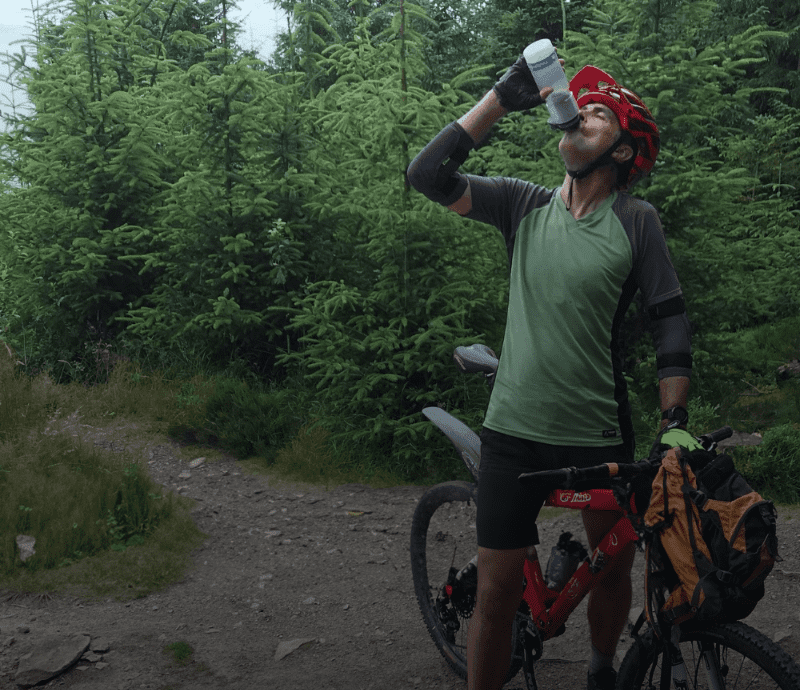 Mountain biker drinking from Water to Go water filter bottle for cycling