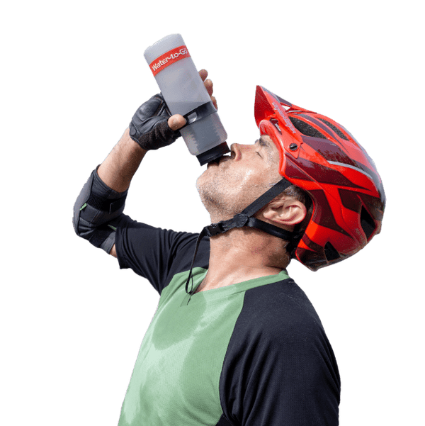 Mountain biker drinking from water filter bottle