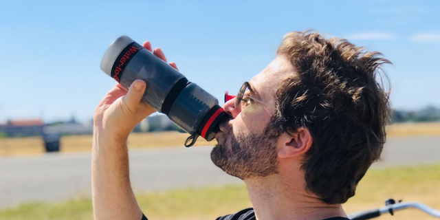 man drinking from water filtration bottle