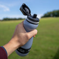 hand holding small water filtration bottle with lid open